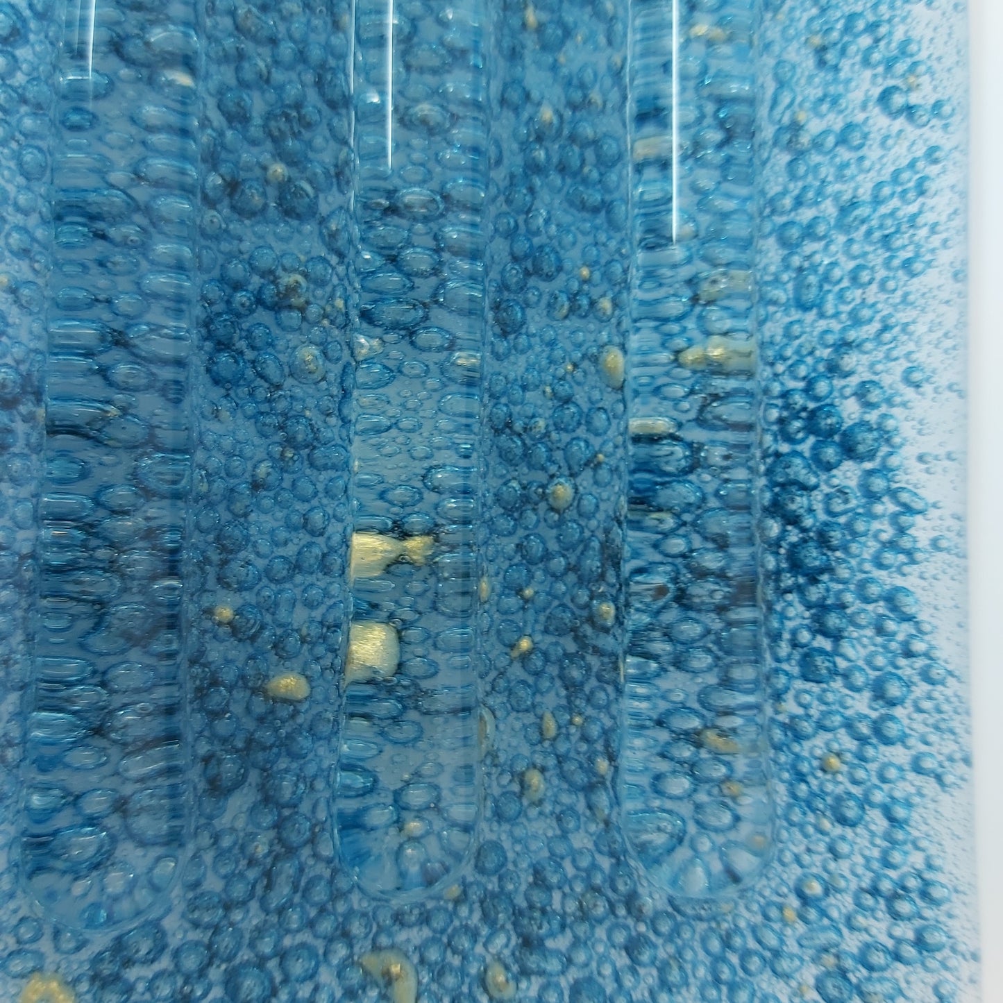 Tvålkopp med blå bubblor och guldstänk